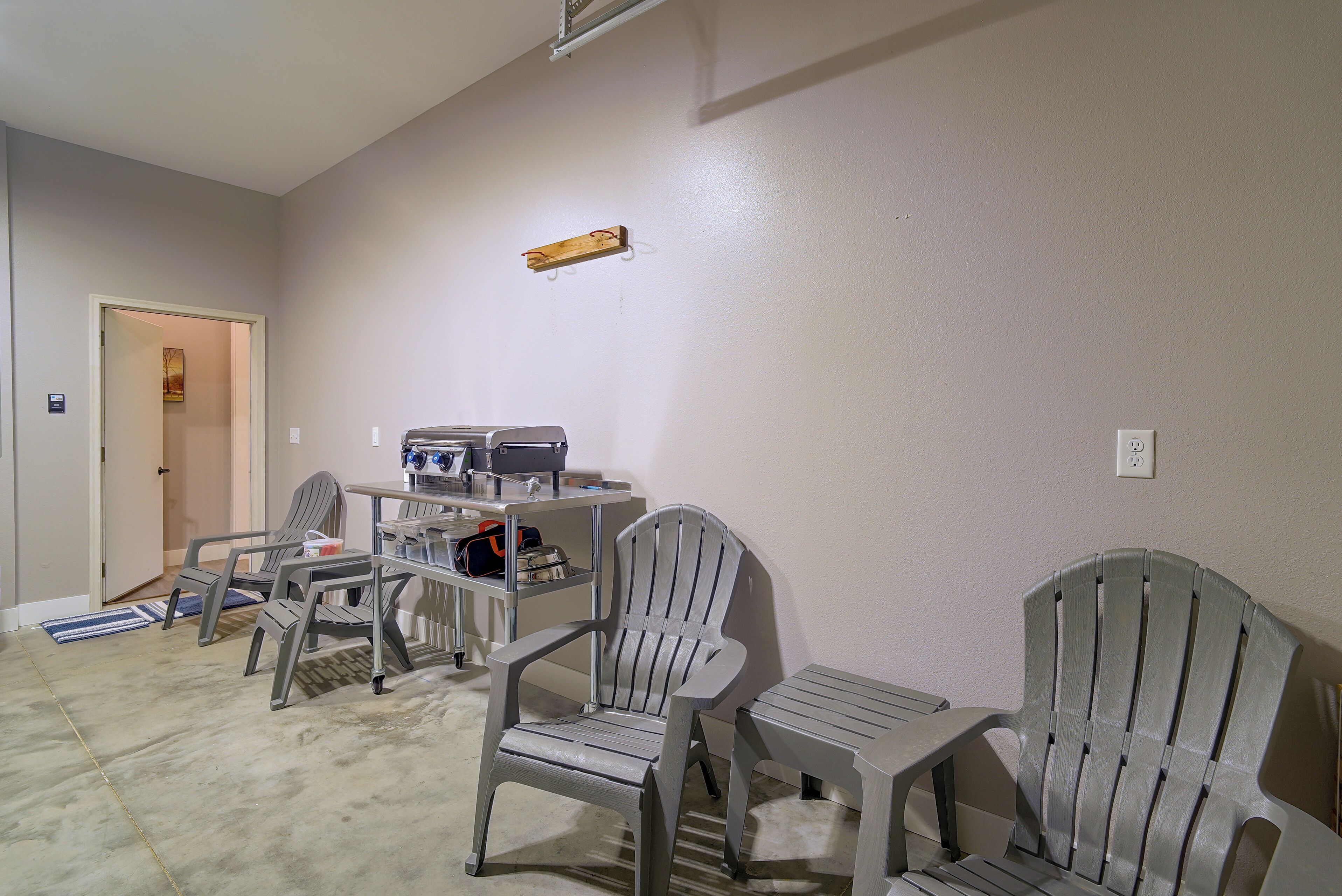 A room with a kitchenette, two chairs, a table, and a door.