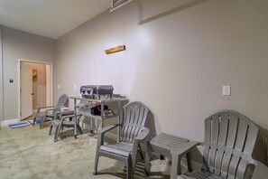 Quarto com cozinha compacta, duas cadeiras, uma mesa e uma porta.