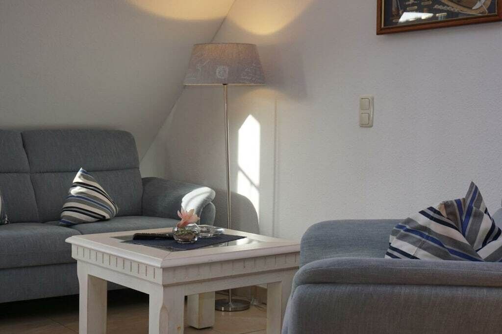 A living room with a sofa, a coffee table, a lamp, and a framed picture on the wall.