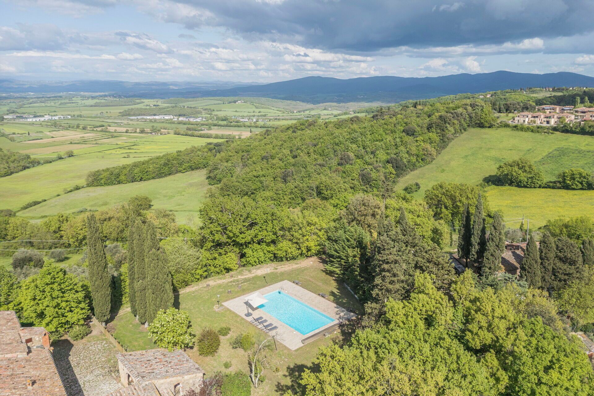 Piscina rodeada por vegetação exuberante e um cenário montanhoso.