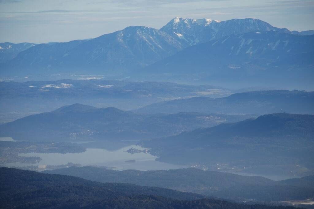 Un paysage montagneux avec un lac et des bâtiments situés au loin.