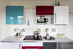 A modern kitchen with a microwave, kettle, coffee maker, and stainless steel sink. - The good life in Karoline's house (Binz)