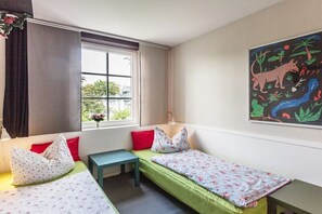 A room with two single beds, a small table, and a window with curtains. - The good life in Karoline's house (Binz)