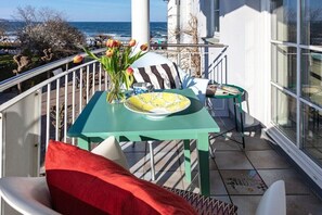 A balcony with a table, chairs, a vase with flowers, and a view of the sea. - The good life in Karoline's house (Binz)