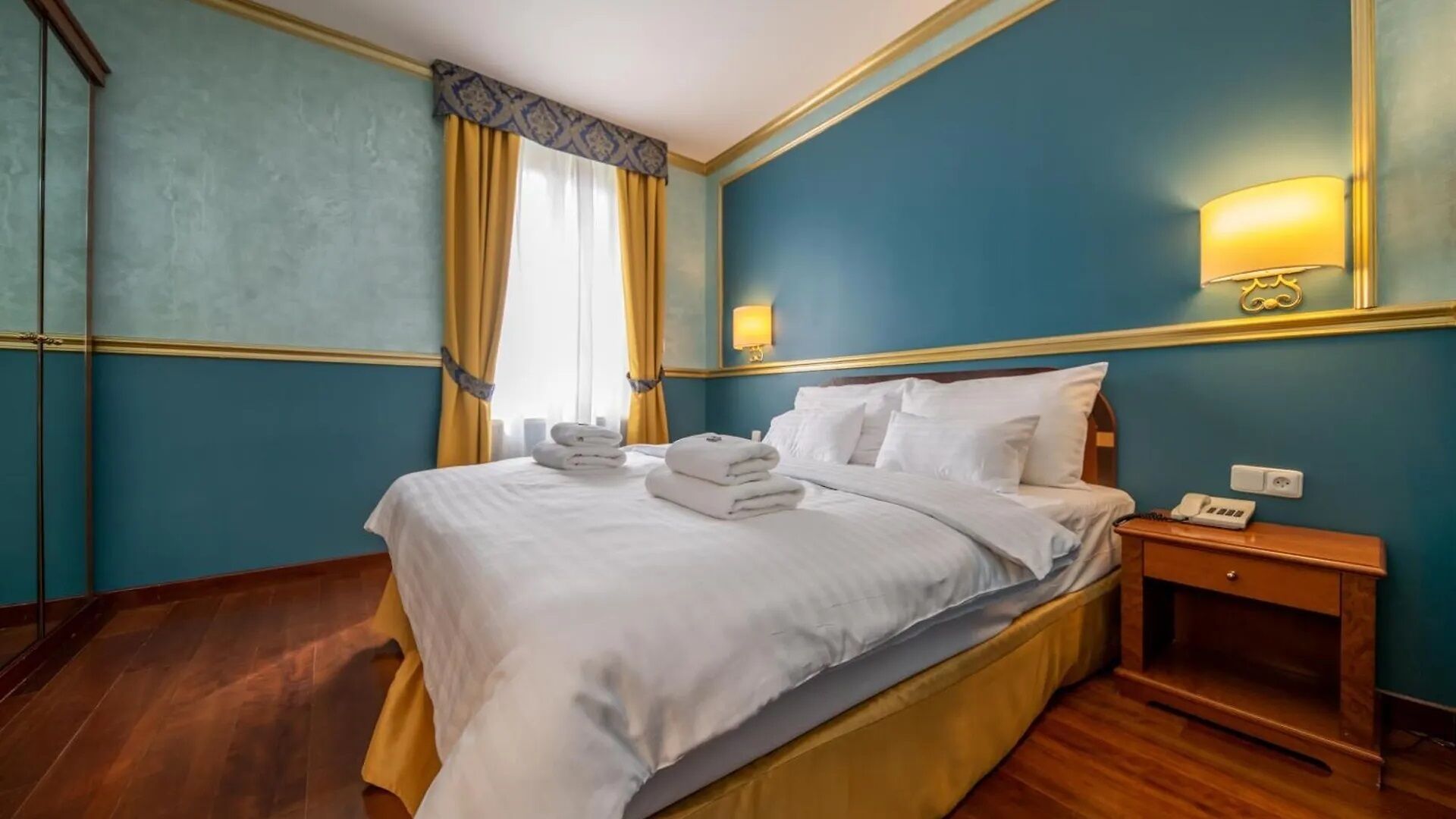 Ein Hotelzimmer mit Bett, Nachttisch und Lampe.