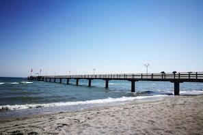 A pier extending into the ocean with a clear sky above. - in the house Stranddüne, No. 14 (Haffkrug)