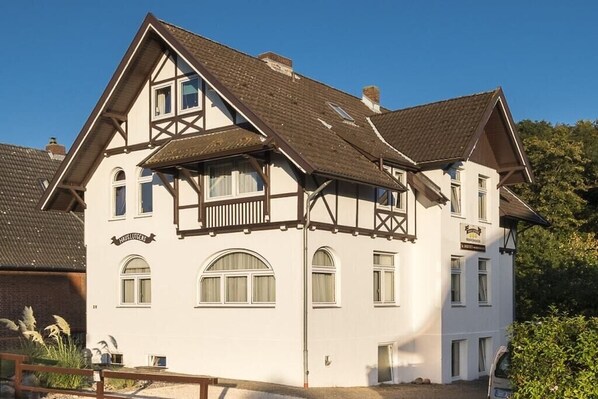 A traditional two-story building with a gabled roof, multiple windows, and a sign indicating it is a hotel. - Holiday apartment with 1 bedroom (Travemünde)