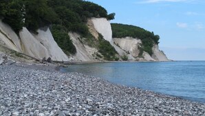 A pebbled beach with cliffs and greenery. - Villa Agnes Apartment 11 (Binz)