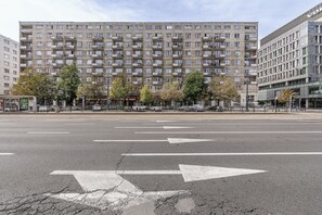 A multi-story residential building with balconies and a row of trees in front. - Lumina 2room Apart with Balcony 6 guests (Warszawa)