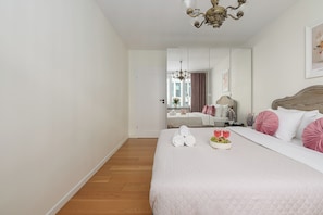 A hotel room with a bed, a bedside table, a mirror, and a chandelier. - Lumina 2room Apart with Balcony 6 guests (Warszawa)