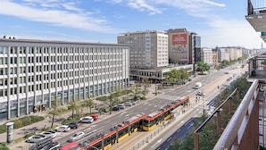 Un carrer urbà amb edificis moderns, un tramvia i un cel serè.
