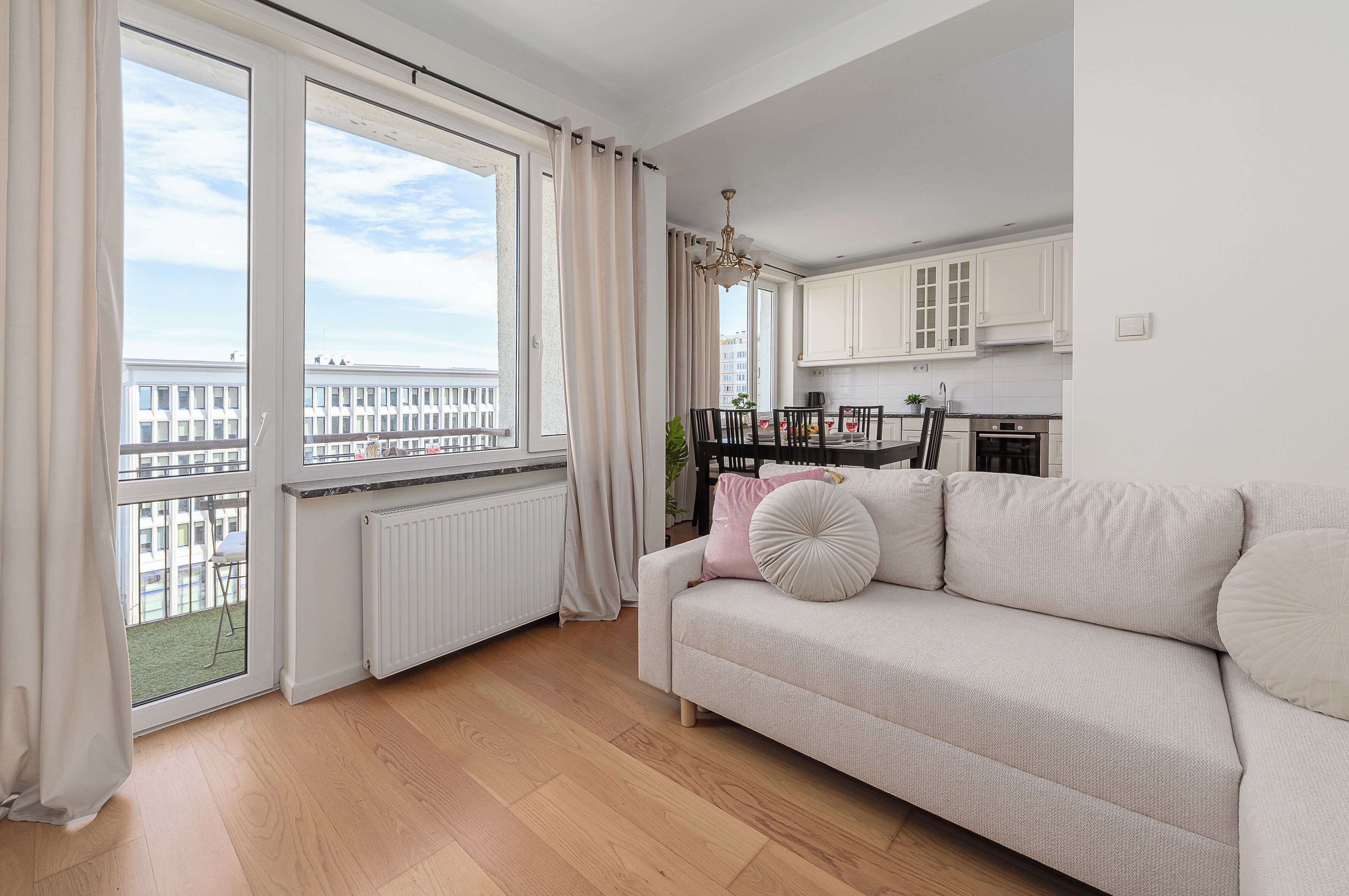 Un appartement moderne comprenant un salon, une cuisine et de grandes fenêtres.