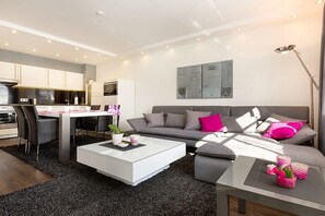 A modern living room with a sofa, coffee table, and dining area. - Sand dune in the Granitz house (Binz)