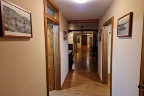 A hallway with wooden floors and doors, leading to a dining area with a ceiling fan. - Holiday apartment in Redwitz with sauna (Redwitz)