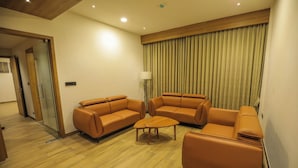 A modern living room with a sofa set, a coffee table, and a lamp.