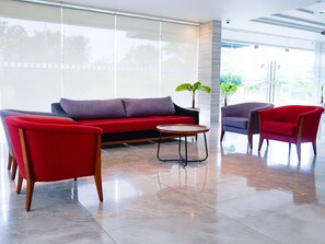 Un interior moderno con un sofá, dos sillones y una pequeña mesa.