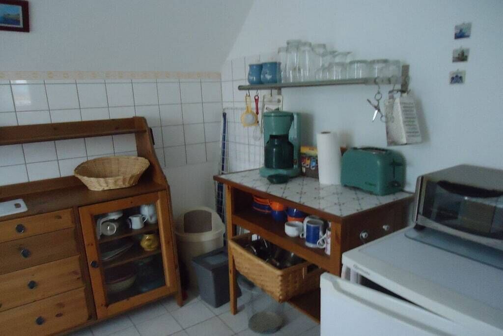 A compact kitchen with a microwave, coffee maker, and a small sink.