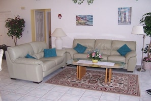 A living room with two sofas, a coffee table, a lamp, and a rug. - Villa in Cape Coral with swimming pool (Cape Coral)
