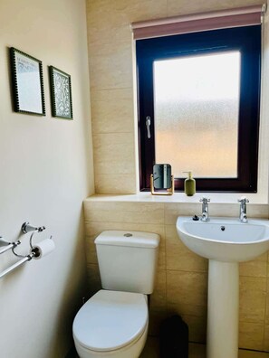 A bathroom with a toilet, sink, and a window with a view. - Bright and Central Paisley Flat Fast Airport and Glasgow Links (Renfrewshire)