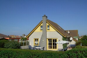 Ein Haus mit Satteldach, Schornstein und Satellitenschüssel.