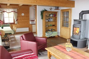 Ein gemütliches Wohnzimmer mit Kamin, Essbereich und Bücherregal.
