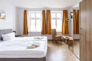 A hotel room with a bed, a chair, a small table, and a wardrobe. - "Beach chair" at the Baltic Sea resort Sandburg (Kühlungsborn)