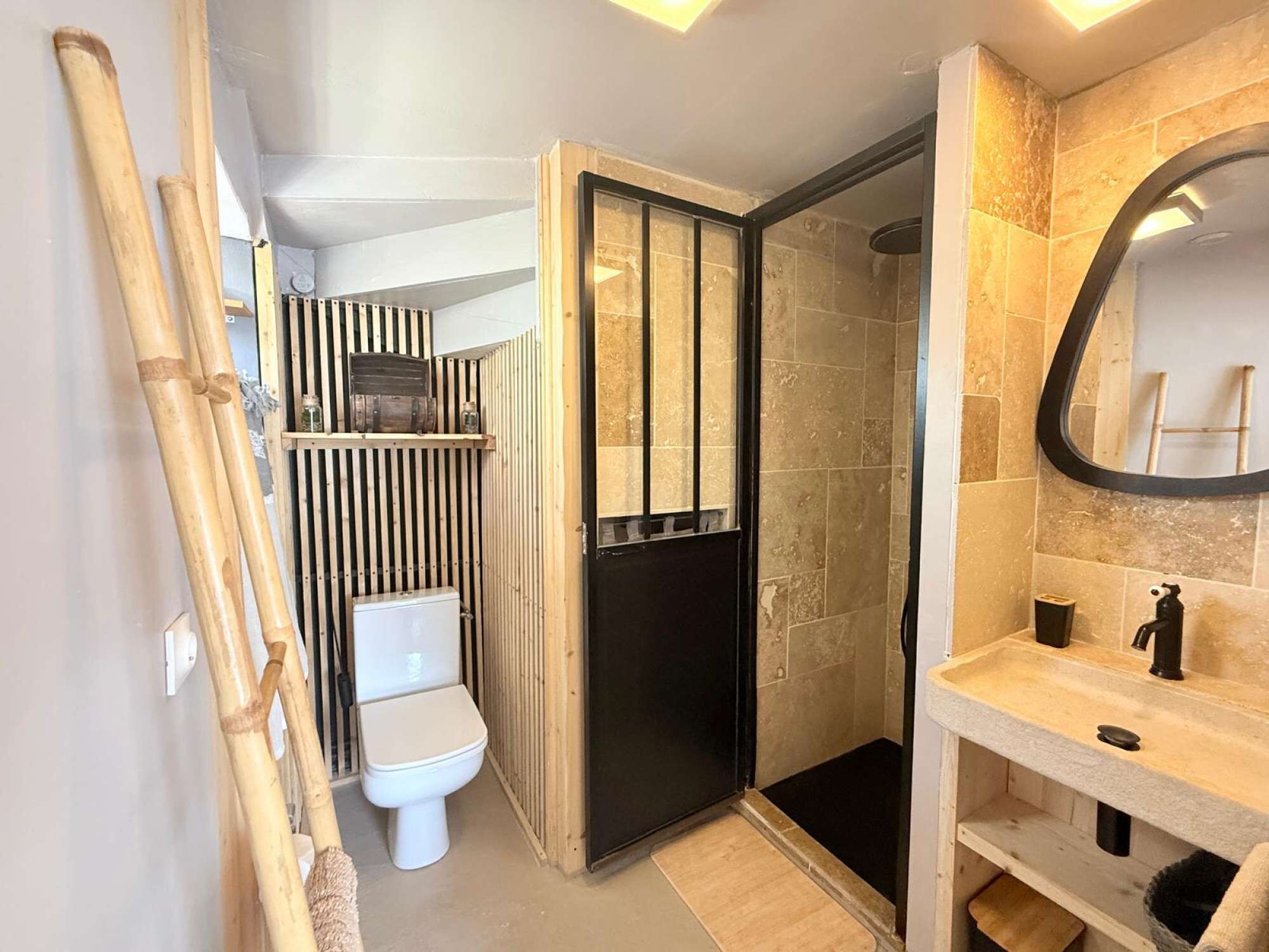Een moderne badkamer met toilet, douche en wastafel.