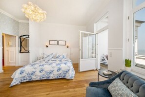 Makuuhuoneessa on suuri sänky, sohva, kattokruunu ja lasiliukuovi, joka johtaa parvekkeelle.
