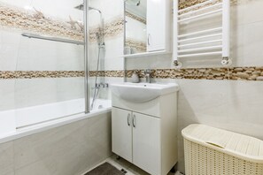 A bathroom with a bathtub, a shower, a sink, and a toilet. - Studio in New Building • Elevator • Quiet Retreat (Chișinău)