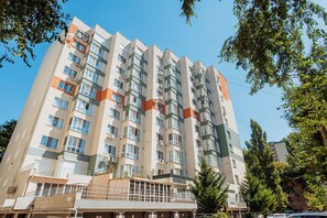 A multi-story residential building with balconies, air conditioning units, and a gated entrance. - Studio in New Building • Elevator • Quiet Retreat (Chișinău)