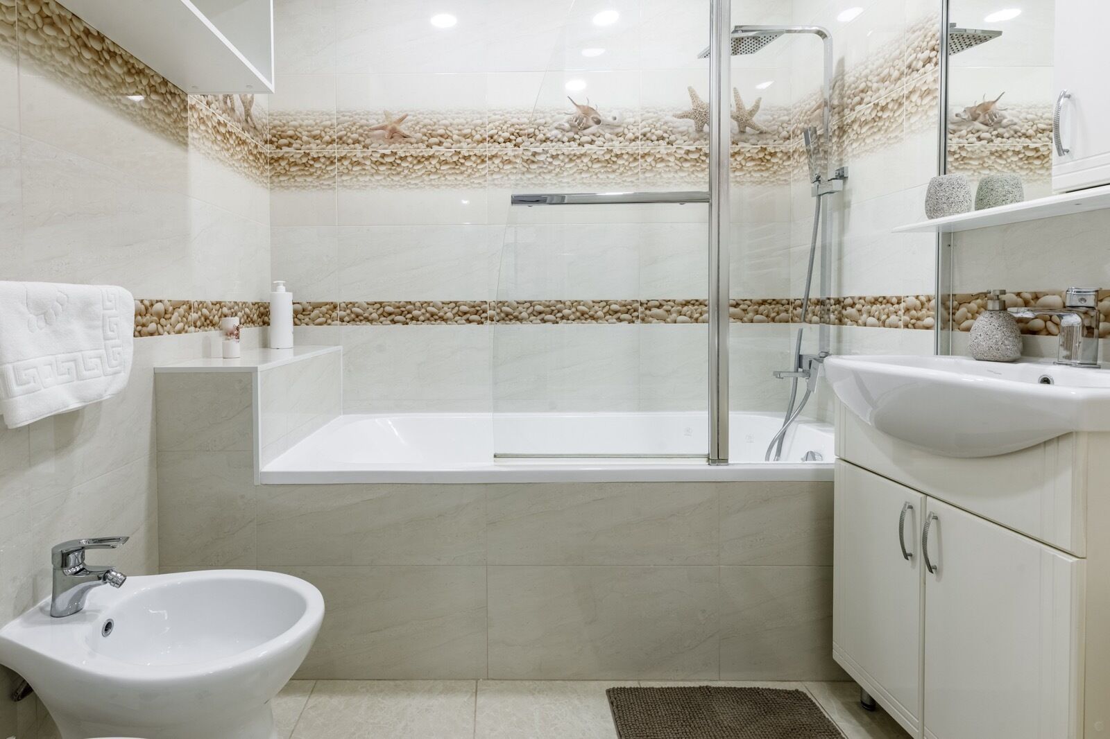 A modern bathroom with a bathtub, a bidet, and a sink.