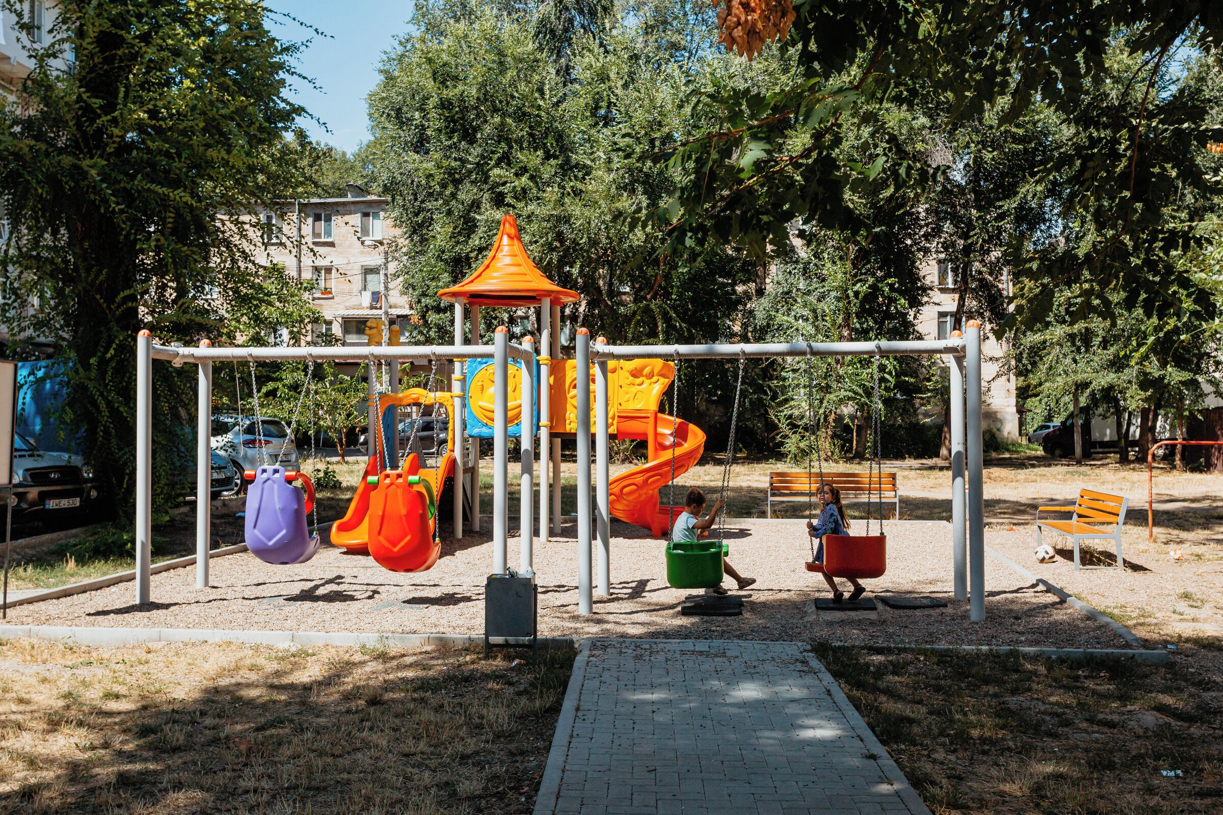 Une aire de jeux avec des balançoires, des toboggans et une structure d’escalade.