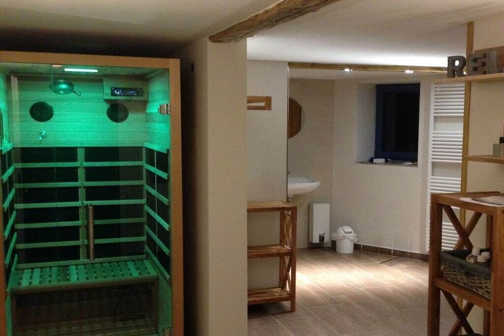 A room with a sauna, a sink, and a window.