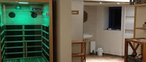 A room with a sauna, a sink, and a window.