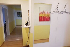 A hallway with a painting, a shelf with items, and a door with a coat rack. - Holiday apartment with 4 bedrooms (Fürth\/Ellenbach)