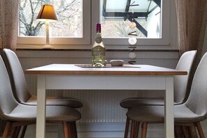 A dining table with two chairs, a bottle, and a lamp. - Holiday apartment with 1 bedroom (Schmallenberg-Grafschaft)