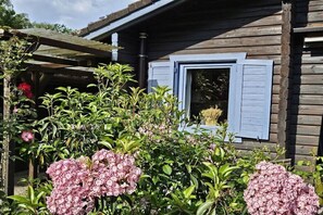 Uma cabana de madeira com janela e varanda de madeira.