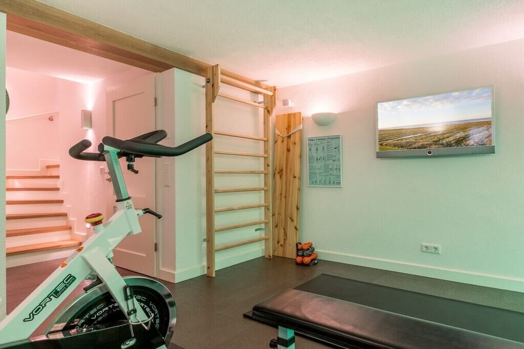 A home gym with a stationary bike, a pull-up bar, and a treadmill.