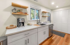 A modern kitchen with a built-in coffee maker, a sink, and wooden shelves. - Tanglewood Tahoe Retreat (South Lake Tahoe)