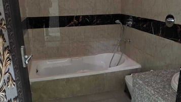 A bathroom with a bathtub, a shower, and a toilet.