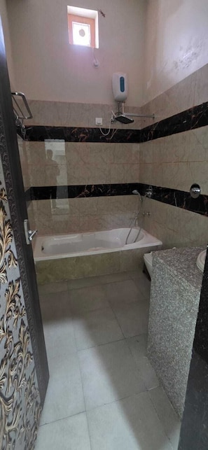 Une salle de bain avec une baignoire, une douche et des toilettes.