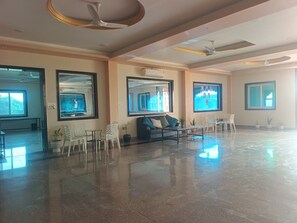 A spacious lobby with a polished floor, seating arrangements, and large windows allowing natural light. - The Arjun Palace By Elaichi Sirohi (Palri)