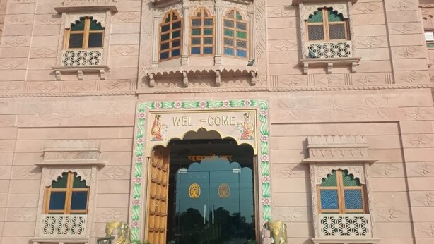 Um hotel com uma placa de destaque que diz 'HOTEL ARJUN PALACE ANDUSHKRA PARTY PLOT'.