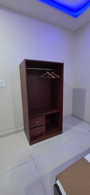 Una habitación con armario, perchero y cama.