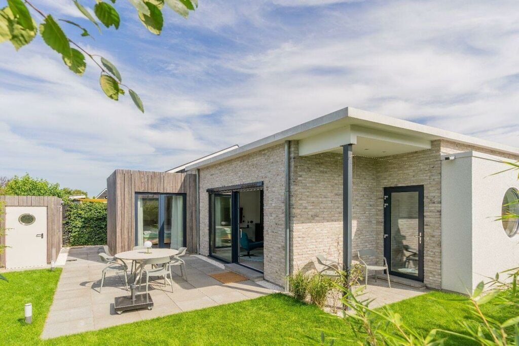 A modern house with a patio, a dining area, and a garage.