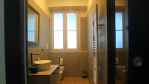 Un baño con un ventanal grande, un lavamanos y un inodoro.