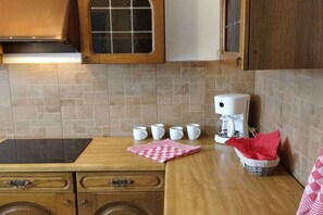 A kitchen with a coffee maker, cups, and a basket. - ||-------------To the ancient pine tree-----------------|| (kiefersfelden)