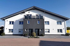 Een modern gebouw met twee verdiepingen, een plat dak, grote ramen en een centrale ingang.
