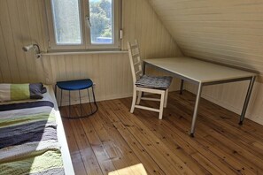 A room with a bed, a desk, and a chair. - Holiday home with 1 bedroom (Heiligenhafen)