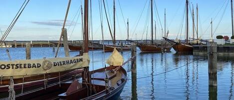 En havn med flere både i havnen, en bro i baggrunden og en klar himmel.